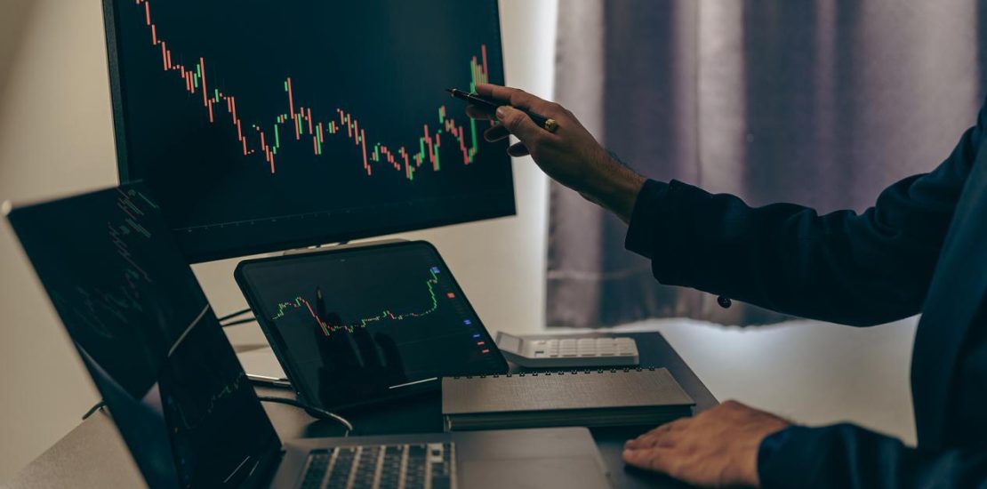 股票交易员看着屏幕上的股票市场图表，分析投资策略，金融工作与屏幕上的股票图表和指标，人们努力做出风险决策