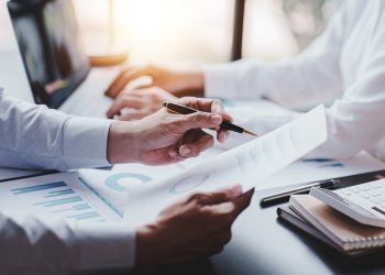 年轻的同事在一个现代化的联合办公办公室里进行精彩的商务对话。团队合作的概念。水平模糊的背景。焰火。