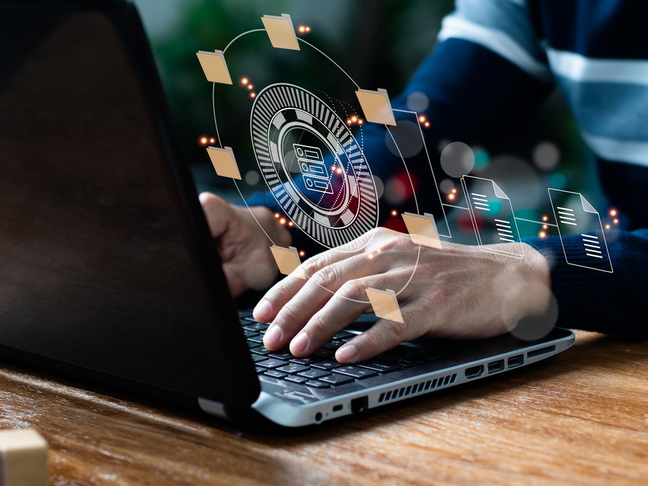 在办公室,一位IT专家正在笔记本电脑上设置文档管理系统(DMS)。企业文件存档软件