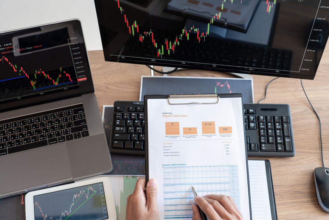 工作的商人，团队的经纪人或交易员谈论外汇在多个电脑屏幕上的股票市场投资交易金融图表数据分析