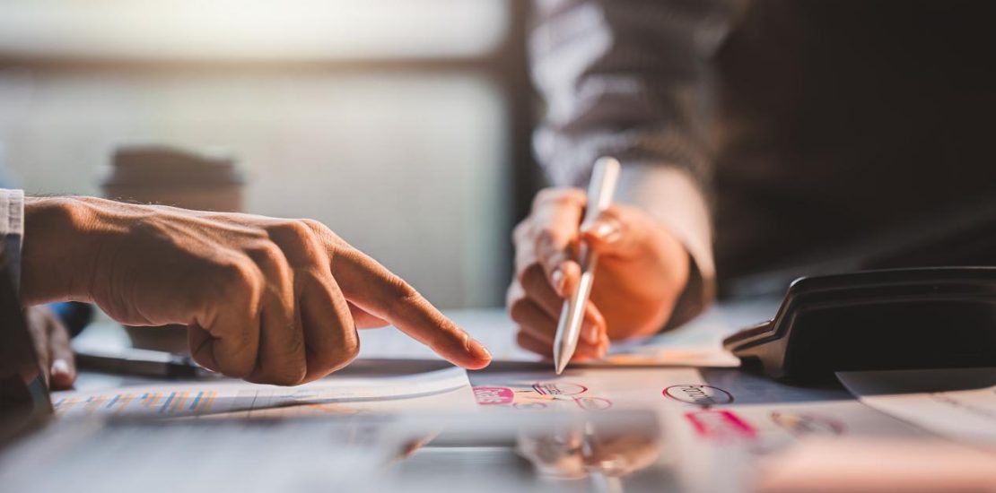 年轻同事讨论业务和价格图表分析商务人士在桌子上伟大的现代联合办公的团队合作理念。为客户计算个税