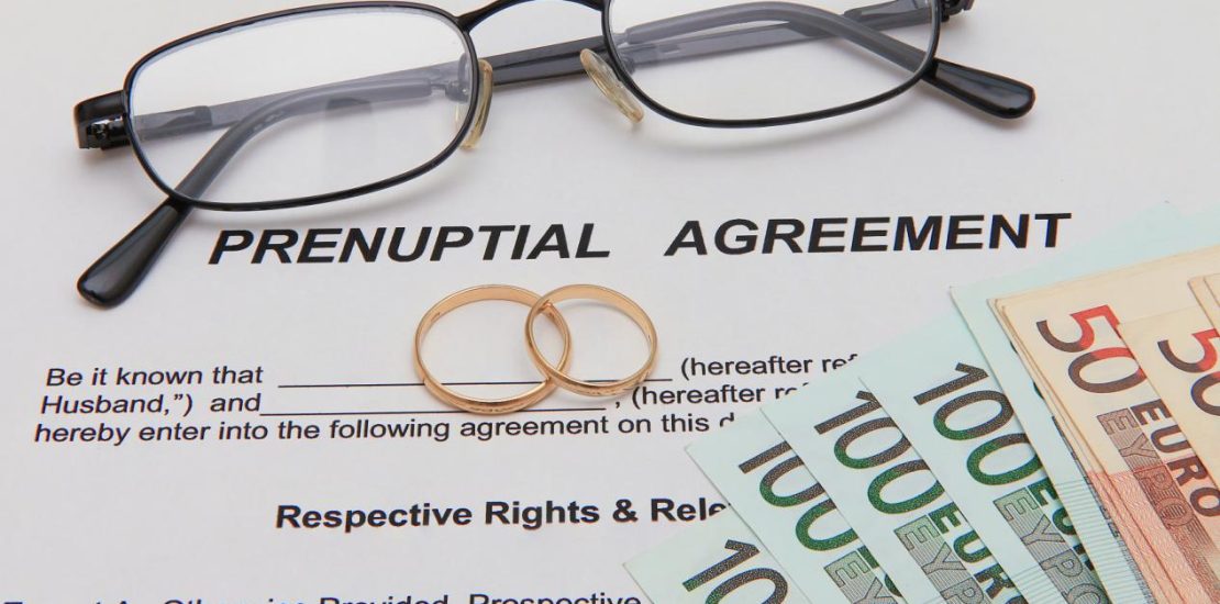 Prenuptial Agreement form and two gold wedding rings