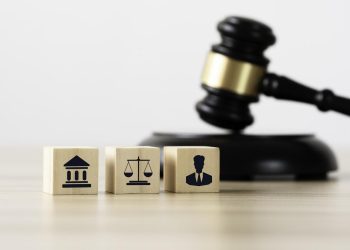 法律律师、法院和法官的图标放在木块上，桌子上的木槌为劳动法的正义和法律概念的公司。