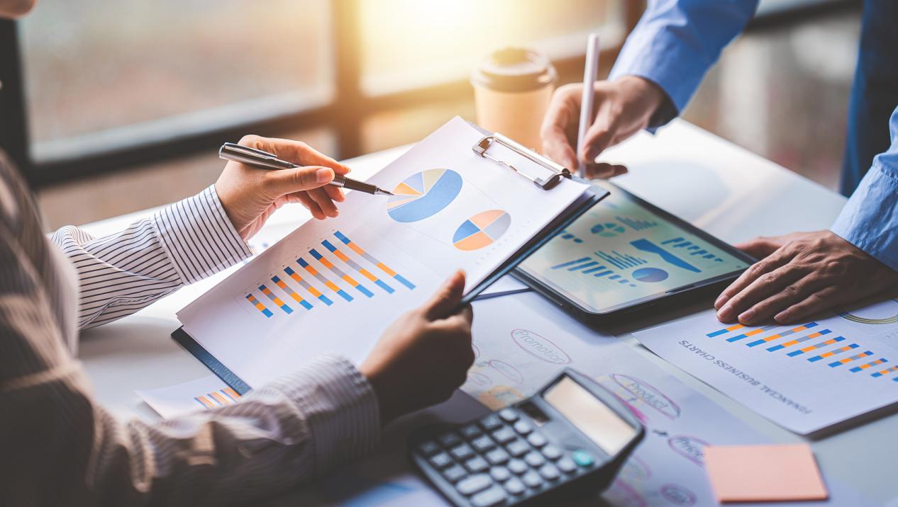 年轻同事讨论业务和价格图表分析商务人士在桌子上伟大的现代联合办公的团队合作理念。为客户计算个税