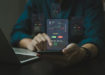 手用手机理财和商业投资理念。股票和加密投资基金。商人分析或交易外汇图表的金融数据烛台图。