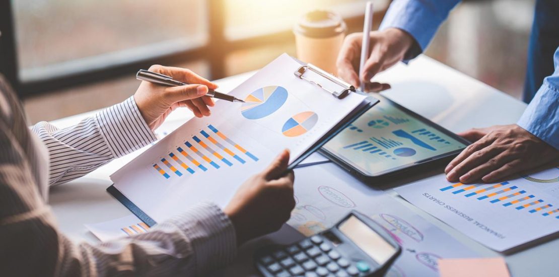 年轻同事讨论业务和价格图表分析商务人士在桌子上伟大的现代联合办公的团队合作理念。为客户计算个税