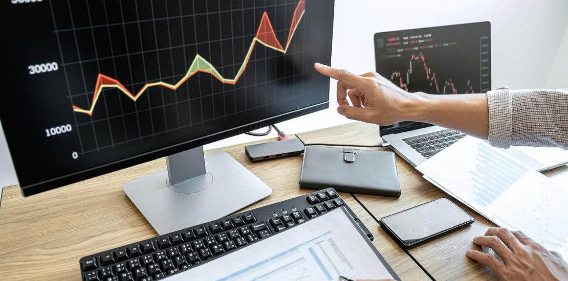 商务团队使用电脑进行投资，规划和分析股票市场交易图表数据，商业金融投资规划概念