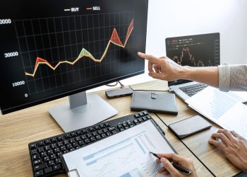 商务团队使用电脑进行投资，规划和分析股票市场交易图表数据，商业金融投资规划概念