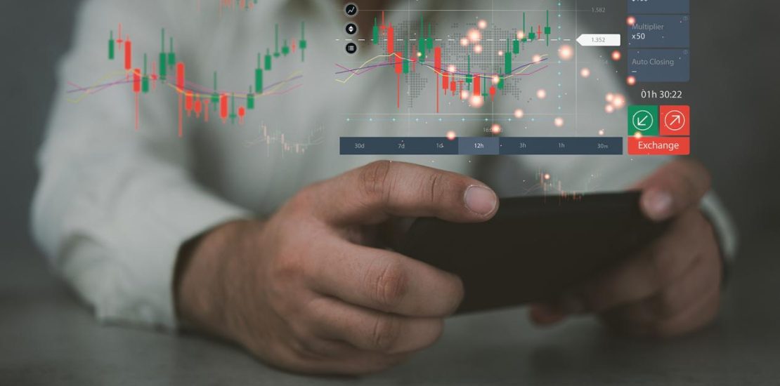 手持智能手机与股票市场图表，全息图与柱状图和不断增长的线。数字和动态变化。