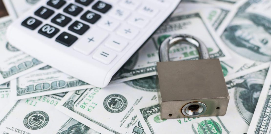 美元钞票背景上の锁とコンピューター